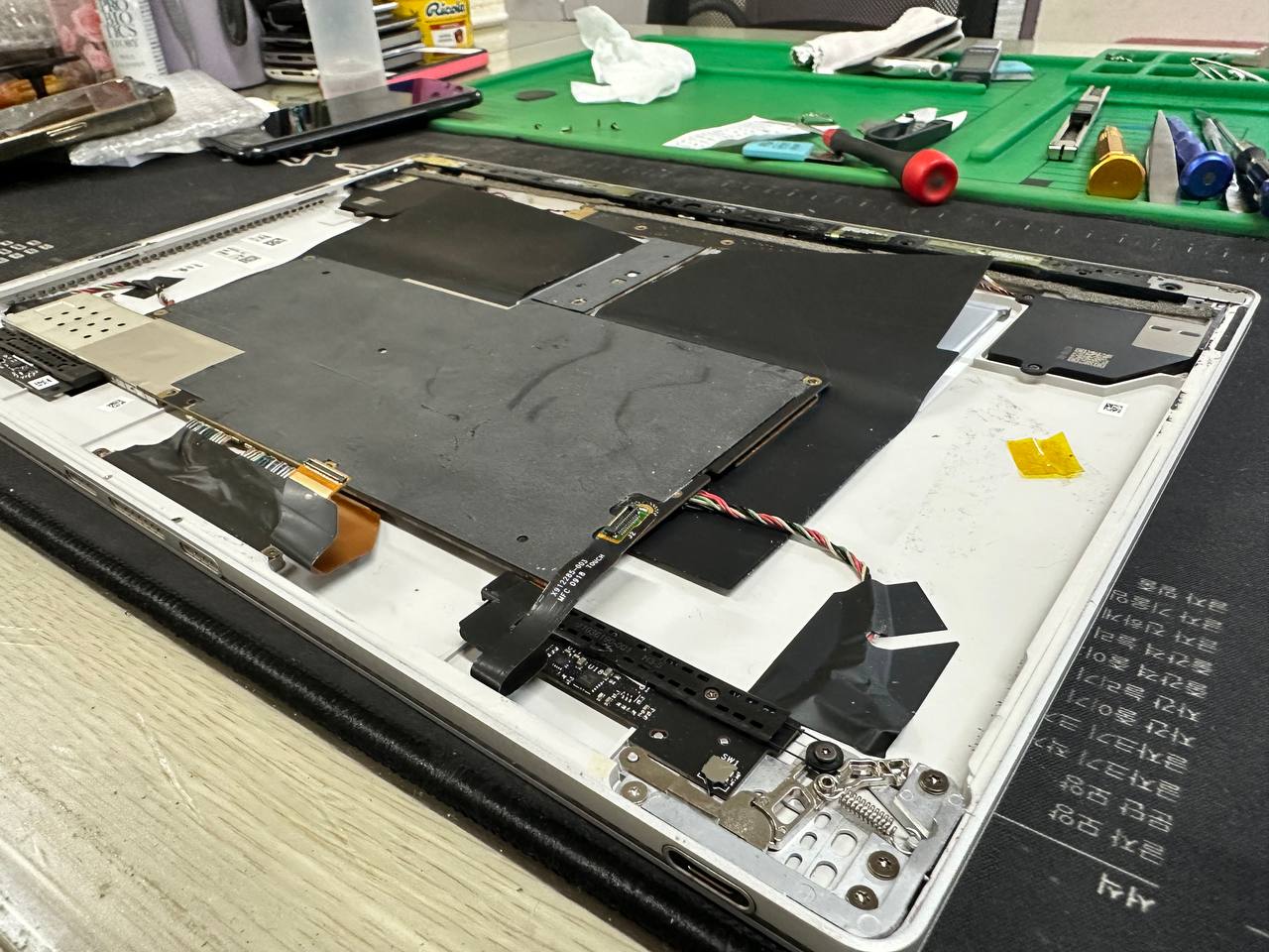 선릉점 마이크로소프트 surface book2 모니터 배터리 스웰링 현상 배터리교체 요청 수리사례 상세사진 5번 이미지입니다. 서피스북2 배터리 스웰링 대전 택배수리 및 액정 벌어짐 교체 완료 관련 2번째 수리 단계로, 수리를 위해 기기를 분해하고 내부 구조를 확인하는 과정입니다.