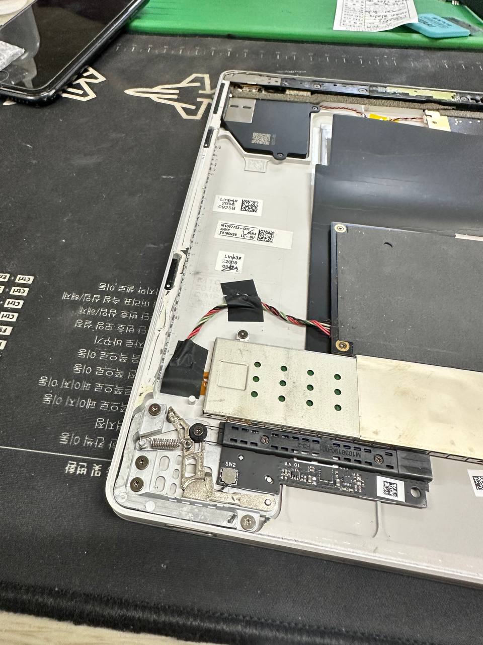 선릉점 마이크로소프트 surface book2 모니터 배터리 스웰링 현상 배터리교체 요청 수리사례 상세사진 6번 이미지입니다. 서피스북2 배터리 스웰링 대전 택배수리 및 액정 벌어짐 교체 완료 관련 2번째 수리 단계로, 내부 커넥터와 주요 부품 상태를 점검하는 분해 작업 이미지입니다.